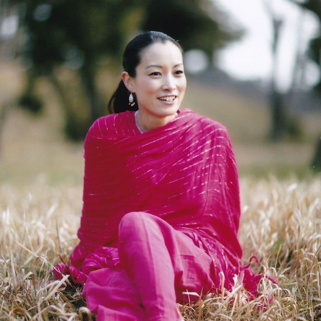 シンプルヨガ主宰の森はま子が森の中で坐っている